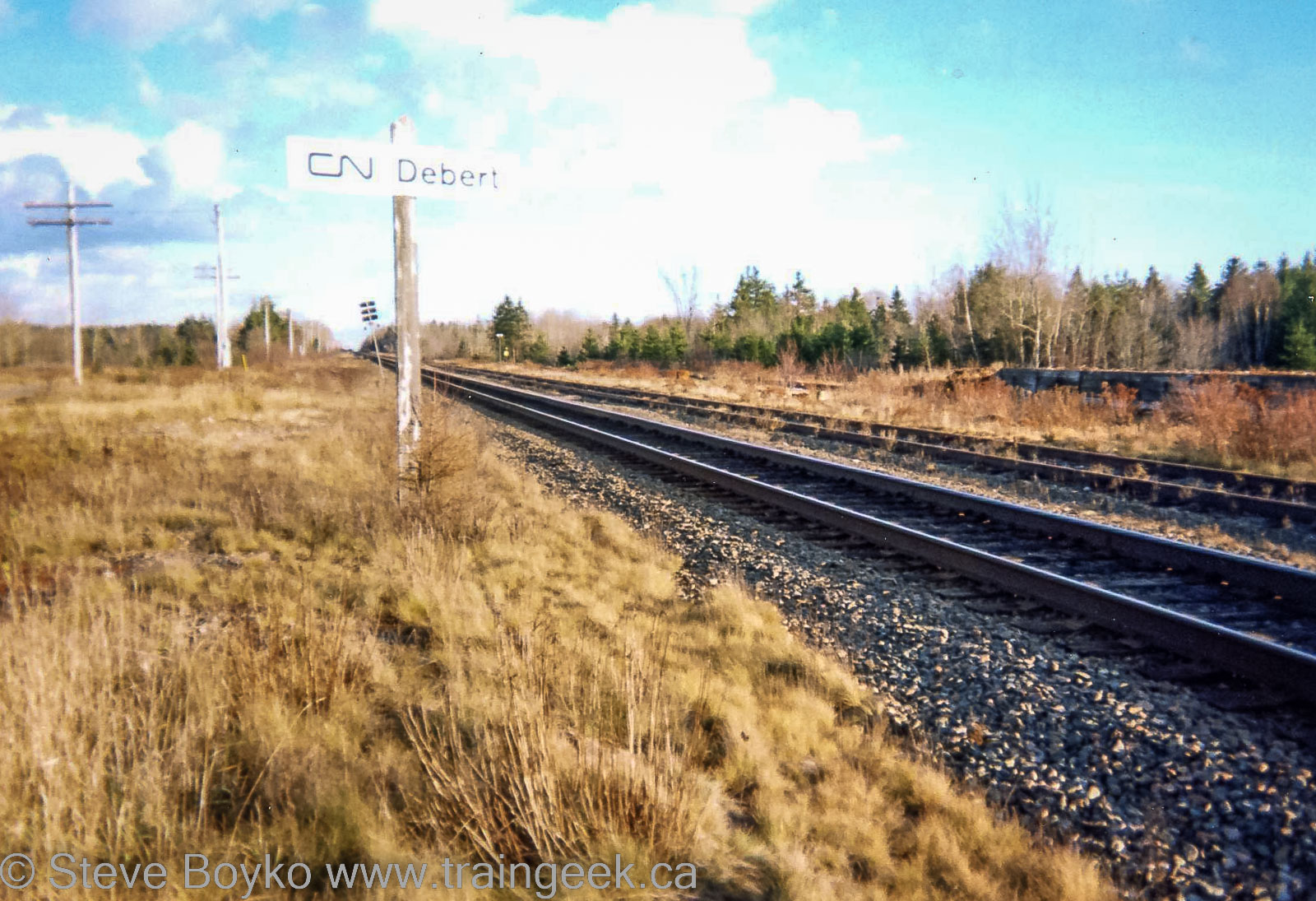 Photograph of railway track with a sign DEBERT
